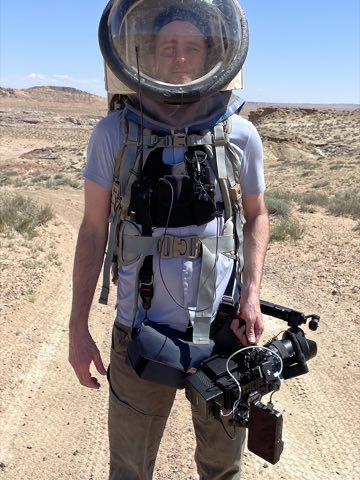 Shooting handheld in a pressure-suit helmet on desert terrain