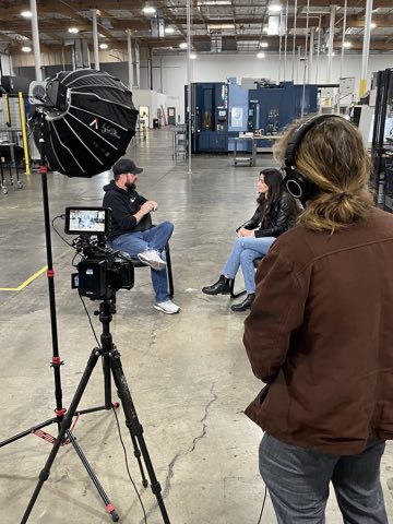 Two-camera interview lit with an Aputure dome on a machine shop floor